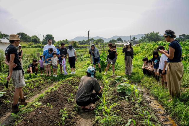 Organisers brief participants on the farmland and crops ahead of an organised event, involving mud races and wrestling matches, in Hong Kong on April 18, 2026. (Photo by Leung Man Hei / AFP)