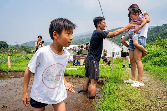Participants gradually enter a muddy field for a trial experience ahead of an organised event, involving mud races and wrestling matches, in Hong Kong on April 18, 2026. (Photo by Leung Man Hei / AFP)