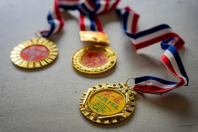 An organiser prepares medals ahead of an organised event, involving mud races and wrestling matches, in Hong Kong on April 18, 2026. (Photo by Leung Man Hei / AFP)