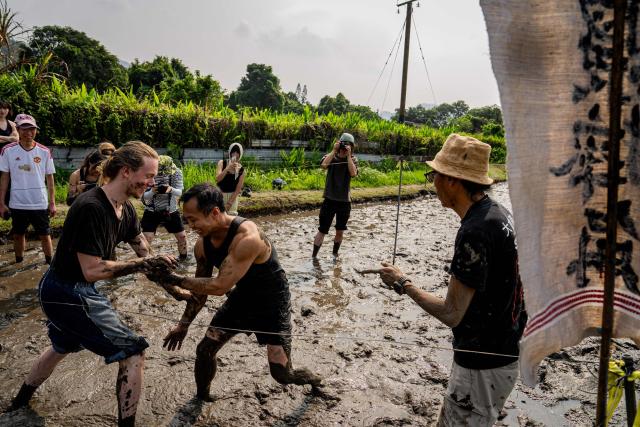 Participants try mud wrestling in a muddy field during an organised event, involving mud races and wrestling matches, in Hong Kong on April 18, 2026. (Photo by Leung Man Hei / AFP)