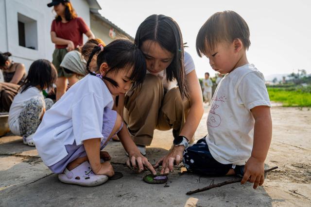 Participants take part in a mud stamp-making activity as part of an organised event, involving mud races and wrestling matches, in Hong Kong on April 18, 2026. (Photo by Leung Man Hei / AFP)