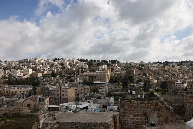 Israeli flags adorn the Ibrahimi Mosque, a holy site known to Jews as the Tombs of the Patriarchs (C), as Israel marks Remembrance Day, commemorating fallen Israeli soldiers, in the Israeli-occupied Palestinian West Bank city of Hebron on April 21, 2026. (Photo by HAZEM BADER / AFP)