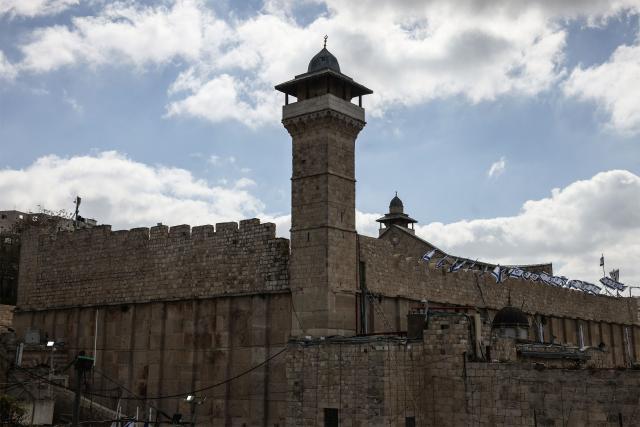 Israeli flags adorn the Ibrahimi Mosque, a holy site known to Jews as the Tombs of the Patriarchs, as Israel marks Remembrance Day, commemorating fallen Israeli soldiers, in the Israeli-occupied Palestinian West Bank city of Hebron on April 21, 2026. (Photo by HAZEM BADER / AFP)