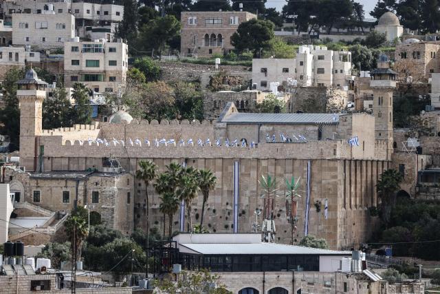 Israeli flags adorn the Ibrahimi Mosque, a holy site known to Jews as the Tombs of the Patriarchs, as Israel marks Remembrance Day, commemorating fallen Israeli soldiers, in the Israeli-occupied Palestinian West Bank city of Hebron on April 21, 2026. (Photo by HAZEM BADER / AFP)