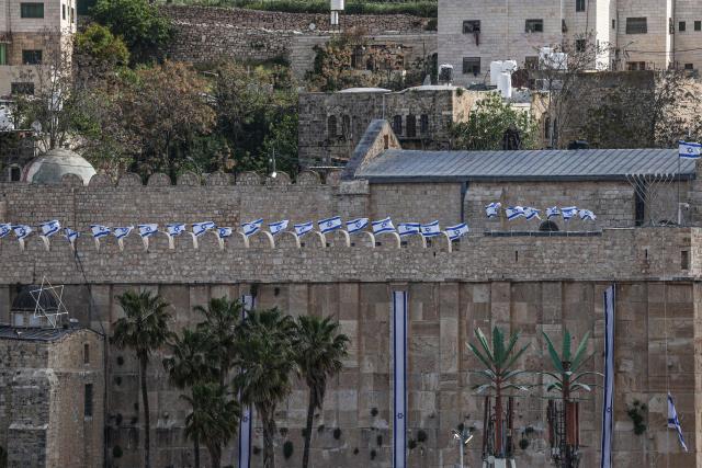 Israeli flags adorn the Ibrahimi Mosque, a holy site known to Jews as the Tombs of the Patriarchs, as Israel marks Remembrance Day, commemorating fallen Israeli soldiers, in the Israeli-occupied Palestinian West Bank city of Hebron on April 21, 2026. (Photo by HAZEM BADER / AFP)