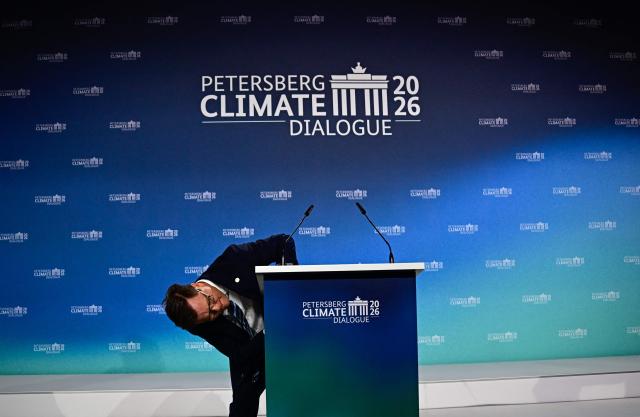 German Minister for the Environment, Climate Protection, Nature Conservation  and Nuclear Safety Carsten Schneider checks out his speaker's desk before addressing guests to open the Petersberg Climate Dialogue (PCD) conference, on April 21, 2026 at the Westhafen Convention Center (WECC) in Berlin. The PCD is a meeting of representatives from selected countries to prepare the yearly UN Climate Change Conferences. The COP31 UN Climate Change Conference will be held in Antalya, Turkey, from November 9 to 20, 2026. (Photo by Tobias SCHWARZ / AFP)