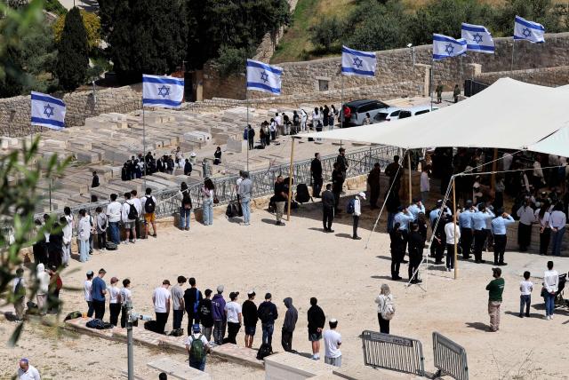 Israelis observe two minutes of silence as they stand on the Mount of Olives as they mark Remembrance Day, which commemorates Israel's fallen soldiers, in Jerusalem on April 21, 2026. (Photo by Ahmad GHARABLI / AFP)