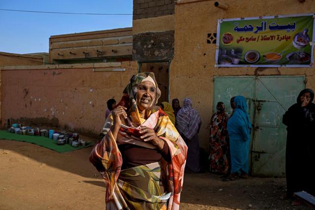 Sudanese Hoda Makki, founder of the “Community Kitchen” initiative, speaks in front of her home where she prepares food for those in need while distributing free meal canisters, in Omdurman on April 21, 2026. The top United Nations official in Sudan told AFP on April 16, 2026, that the country, facing the world's largest humanitarian crisis, has been "abandoned" as the war between the army and the paramilitary Rapid Support Forces (RSF) enters its fourth year. (Photo by Khaled DESOUKI / AFP)