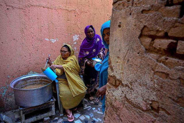 Sudanese women prepare free meal canisters at the home of the founder of the “Community Kitchen” initiative in Omdurman on April 21, 2026. The top United Nations official in Sudan told AFP on April 16, 2026, that the country, facing the world's largest humanitarian crisis, has been "abandoned" as the war between the army and the paramilitary Rapid Support Forces (RSF) enters its fourth year. (Photo by Khaled DESOUKI / AFP)