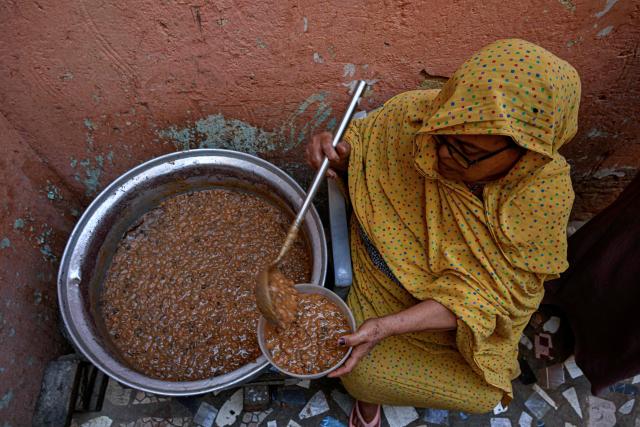 A Sudanese woman prepares a free meal canister at the home of the founder of the “Community Kitchen” initiative in Omdurman on April 21, 2026. The top United Nations official in Sudan told AFP on April 16, 2026, that the country, facing the world's largest humanitarian crisis, has been "abandoned" as the war between the army and the paramilitary Rapid Support Forces (RSF) enters its fourth year. (Photo by Khaled DESOUKI / AFP)