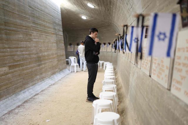 An Israeli contemplates as people gather at the Military Cemetery on Mount Herzl commemorating Israel's Remembrance Day for fallen soldiers or Yom HaZikaron, in Jerusalem on April 21, 2026. (Photo by Ilia YEFIMOVICH / AFP)