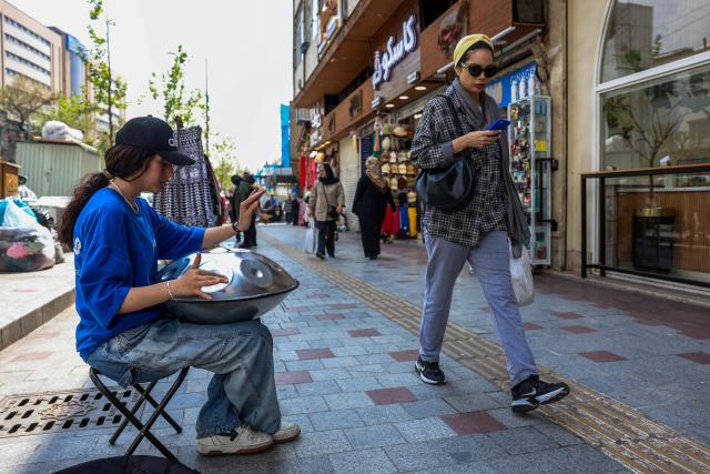 A musician plays a hang drum on a street in Tehran on April 21, 2026, amid a ceasefire in the region. With the end of a two-week ceasefire approaching, the White House said US Vice President JD Vance was ready to return to Pakistan for fresh negotiations to end a conflict that has sent crude soaring and revived inflation fears. (Photo by AFP) / 