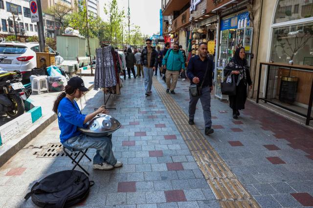 A musician plays a hang drum on a street in Tehran on April 21, 2026, amid a ceasefire in the region. With the end of a two-week ceasefire approaching, the White House said US Vice President JD Vance was ready to return to Pakistan for fresh negotiations to end a conflict that has sent crude soaring and revived inflation fears. (Photo by AFP) / 