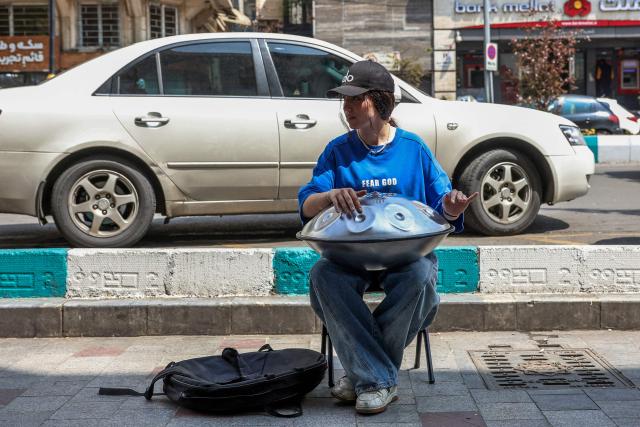 A musician plays a hang drum on a street in Tehran on April 21, 2026, amid a ceasefire in the region. With the end of a two-week ceasefire approaching, the White House said US Vice President JD Vance was ready to return to Pakistan for fresh negotiations to end a conflict that has sent crude soaring and revived inflation fears. (Photo by AFP) / 
