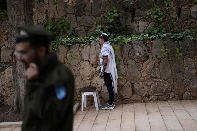 Israelis gather at the Military Cemetery on Mount Herzl commemorating Israel's Remembrance Day for fallen soldiers or Yom HaZikaron, in Jerusalem on April 21, 2026. (Photo by Ilia YEFIMOVICH / AFP)