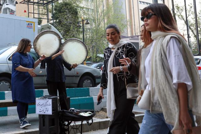 Musicians perform on a street in Tehran on April 21, 2026, amid a ceasefire in the region. With the end of a two-week ceasefire approaching, the White House said US Vice President JD Vance was ready to return to Pakistan for fresh negotiations to end a conflict that has sent crude soaring and revived inflation fears. (Photo by AFP) / 