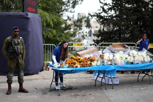 Flowers are available for people arriving at the Military Cemetery on Mount Herzl to commemorate Israel's Remembrance Day for fallen soldiers or Yom HaZikaron, in Jerusalem on April 21, 2026. (Photo by Ilia YEFIMOVICH / AFP)