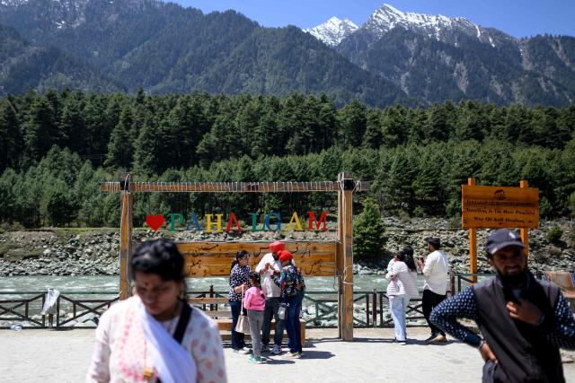 Tourists visit the selfie point along the banks of Lidder river in Pahalgam in south Kashmir’s Anantnag district on April 21, 2026. Relations between nuclear-armed neighbours India and Pakistan plummeted last year after an attack in Indian-administered Kashmir killed 26 men, mostly Hindu tourists, leading to their worst conflict in decades. Gunmen burst out of forests near the resort town of Pahalgam on April 22, 2025 and raked crowds of visitors with automatic weapons. (Photo by MANAN VATSYAYANA / AFP)