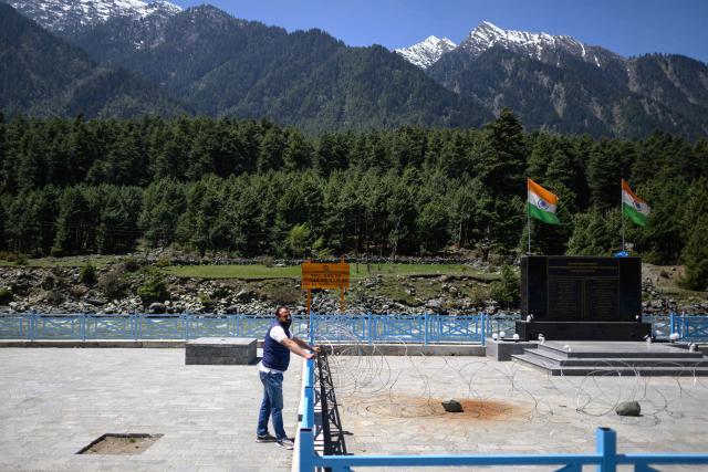 A man stands at the memorial site for the victims of last year’s Baisaran Valley terror attack, along the banks of Lidder river in Pahalgam in south Kashmir’s Anantnag district on April 21, 2026. Relations between nuclear-armed neighbours India and Pakistan plummeted last year after an attack in Indian-administered Kashmir killed 26 men, mostly Hindu tourists, leading to their worst conflict in decades. Gunmen burst out of forests near the resort town of Pahalgam on April 22, 2025 and raked crowds of visitors with automatic weapons. (Photo by MANAN VATSYAYANA / AFP)