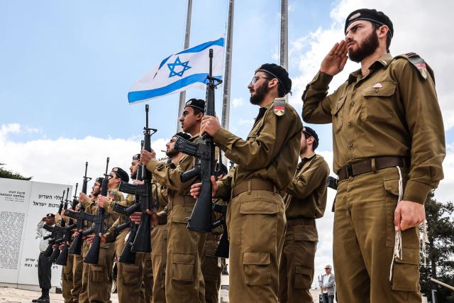 Israelis observe a two minute silence as they gather at the Military Cemetery on Mount Herzl commemorating Israel's Remembrance Day for fallen soldiers or Yom HaZikaron, in Jerusalem on April 21, 2026. (Photo by Jack GUEZ / AFP)