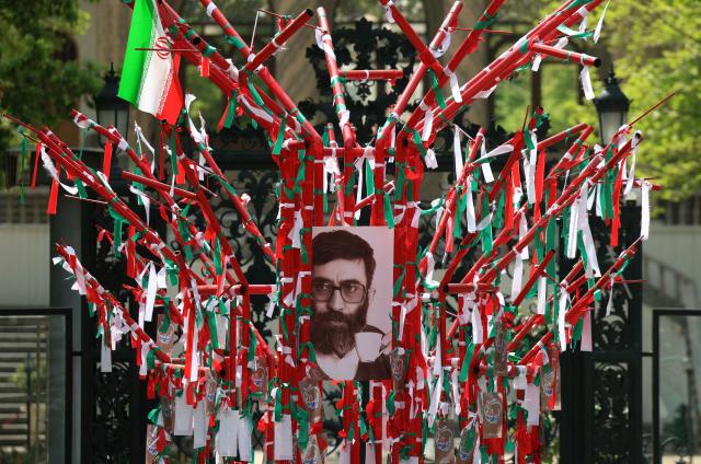 A structure adorned with Iranian flags and a portrait of the late Iranian supreme leader Ayatollah Ali Khamenei as a young man, is placed in a park in northern Tehran on April 21, 2026, amid a ceasefire in the region. With the end of a two-week ceasefire approaching, the White House said US Vice President was ready to return to Pakistan for fresh negotiations to end a conflict that has sent crude soaring and revived inflation fears. (Photo by AFP) / 