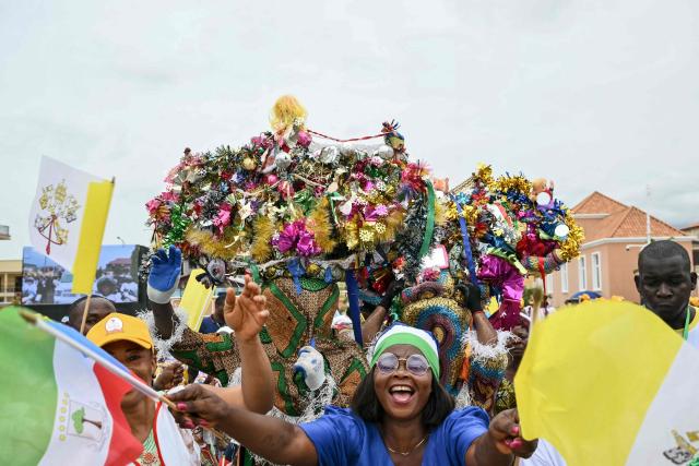 Residents cheer as they gather outside where Pope Leo XIV will meet with authorities, civil society and the diplomatic corps at the Presidential Palace in Malabo on the ninth day of an 11-day apostolic journey to Africa, on April 21, 2026. (Photo by Alberto PIZZOLI / AFP)
