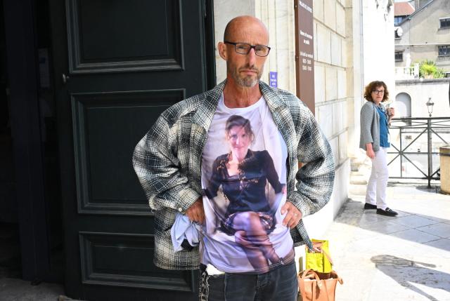 Agnes Lassalle's partner Stephane Voirin poses for the the press at the entrance of the Pau courthouse as he wears a t-shirt honouring his late wife on the first day of the trial of her murderer in Pau, south-western France on April 21, 2026. The trial of the student accused of murdering Agnes Lassalle, a Spanish teacher stabbed to death in her classroom in 2023 in Saint-Jean-de-Luz, opened on April 21, 2026, behind closed doors before the juvenile assize court of the Pyrenees-Atlantiques, as judges examine in particular the criminal responsibility of the accused. (Photo by Gaizka IROZ / AFP)