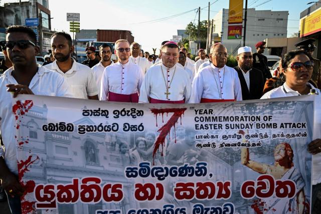 Sri Lankas Roman Catholic Cardinal Malcolm Ranjith (center R) and Apostolic Nuncio (Vatican Ambassador to Sri Lanka) Monsignor Andrez Jozwowlez (C) take part in a silent march outside St Sebastian's Church in Katuwapitiya marking the seventh anniversary of the 2019 Easter Sunday bombings on April 21, 2026. The United Nations urged Sri Lanka on April 21 to deliver concrete results after long-running investigations into the 2019 Easter Sunday suicide bombings that killed 279 people, including 45 foreigners. (Photo by Ishara S. KODIKARA / AFP)