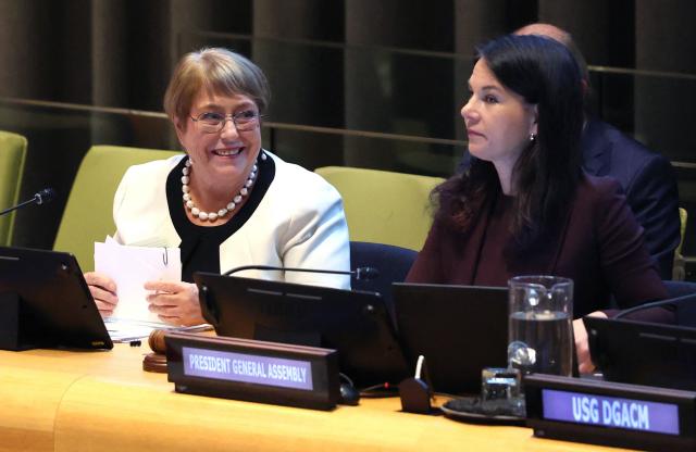 Former Chilean president Michelle Bachelet (L) speaks with Annalena Baerbock, President of the UN General Assembly, during a hearing for Bachelet to be considered as the next Secretary-General of the United Nations at the UN Headquarters in New York, on April 21, 2026. Bachelet is among four candidates vying for the position currently held by Portugal's Antonio Guterres. (Photo by TIMOTHY A. CLARY / AFP)