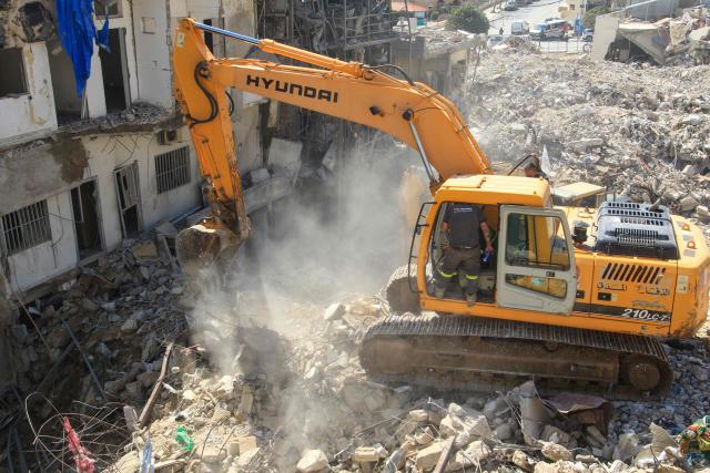 A digger removes the rubble of buildings destroyed in Israeli strikes, as the search for survivors buried underneath continues in the southern Lebanese coastal city of Tyre on April 21, 2026. Israeli defence minister said on April 21 that his country's campaign in Lebanon relied on both military and diplomatic pressure to disarm Iran-allied Hezbollah. Though a truce between Israel and Lebanon took effect on April 17, Israeli troops are still present and actively fighting Hezbollah militants in Lebanon's south. (Photo by Mahmoud ZAYYAT / AFP)