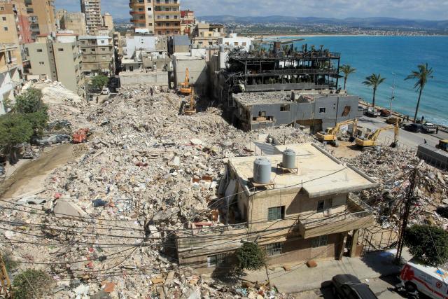 Diggers remove the rubble of buildings destroyed in Israeli strikes as they look for survivors buried underneath in the southern Lebanese coastal city of Tyre on April 21, 2026. Israeli defence minister said on April 21 that his country's campaign in Lebanon relied on both military and diplomatic pressure to disarm Iran-allied Hezbollah. Though a truce between Israel and Lebanon took effect on April 17, Israeli troops are still present and actively fighting Hezbollah militants in Lebanon's south. (Photo by Mahmoud ZAYYAT / AFP)