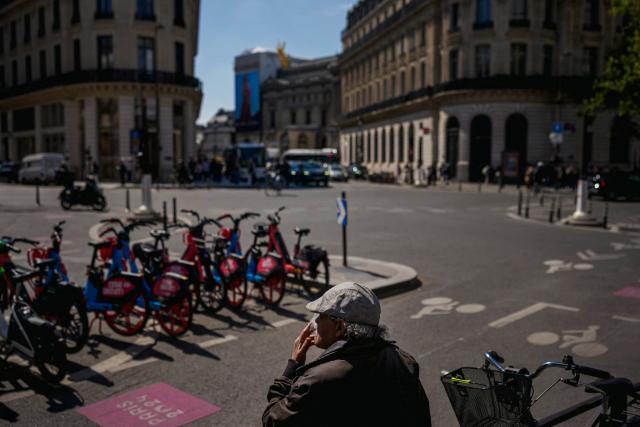 A man smokes a cigarette on a street in central Paris on April 21, 2026. (Photo by Dimitar DILKOFF / AFP)