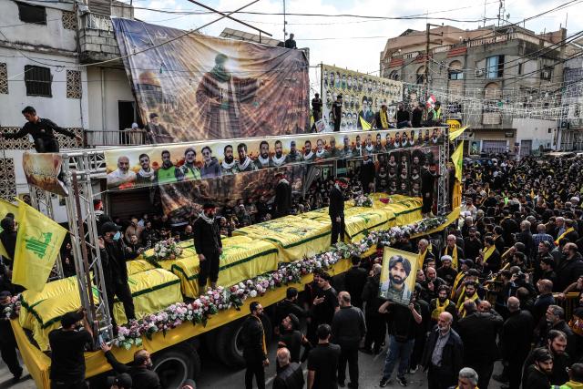 Mourners attend a mass funeral procession for Hezbollah fighters, killed before a 10-day ceasefire was agreed between the Iran-backed militant group and Israel, in the southern village of Kfar Sir on April 21, 2026. Israeli defence minister said on April 21 that his country's campaign in Lebanon relied on both military and diplomatic pressure to disarm Iran-allied Hezbollah. Though a truce between Israel and Lebanon took effect on April 17, Israeli troops are still present and actively fighting Hezbollah militants in Lebanon's south. (Photo by ANWAR AMRO / AFP)