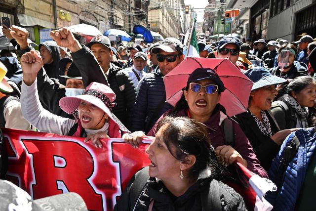 Rural education workers shout slogans as they march through the central streets of La Paz on April 21, 2026, demanding a wage increase for their sector. (Photo by Aizar RALDES / AFP)