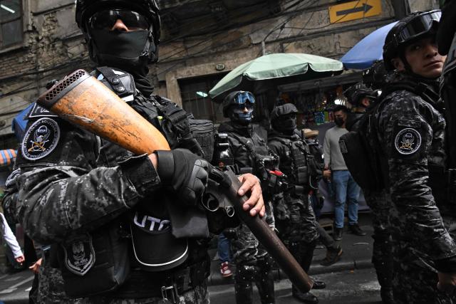 Riot police guard the Plaza Murillo during a rural education workers march through the central streets of La Paz on April 21, 2026, in demand of a wage increase for their sector. (Photo by Aizar RALDES / AFP)