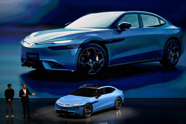 Volkswagen's new ID. UNYX 09 electric car model is presented by CEO of Volkswagen Passenger Cars Thomas Schafer (R) at an event ahead of the Beijing Auto Show 2026 in Beijing on April 21, 2026. (Photo by Pedro PARDO / AFP)