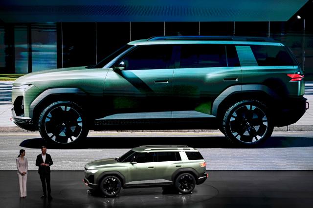 A model of the new JETTA X electric SUV is presented by CEO of Volkswagen Passenger Cars Thomas Schafer (R) at an event ahead Beijing Auto Show 2026 in Beijing on April 21, 2026. (Photo by Pedro PARDO / AFP)