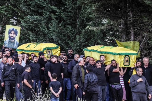 Mourners carry coffins during a mass funeral procession for Hezbollah fighters, killed before a 10-day ceasefire was agreed between the Iran-backed militant group and Israel, in the southern village of Kfar Sir on April 21, 2026. Israeli defence minister said on April 21 that his country's campaign in Lebanon relied on both military and diplomatic pressure to disarm Iran-allied Hezbollah. Though a truce between Israel and Lebanon took effect on April 17, Israeli troops are still present and actively fighting Hezbollah militants in Lebanon's south. (Photo by Anwar AMRO / AFP)