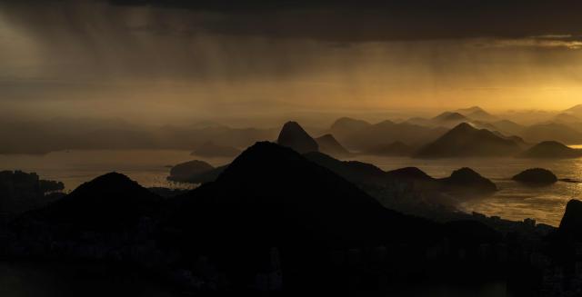 General view of Guanabara bay under at sunrise during a rainy morning in Rio de Janeiro, Brazil on April 21, 2026. (Photo by Pablo PORCIUNCULA / AFP)