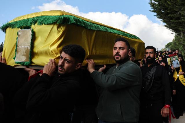 Mourners carry a coffin during a mass funeral procession for Hezbollah fighters, killed before a 10-day ceasefire was agreed between the Iran-backed militant group and Israel, in the southern village of Kfar Sir on April 21, 2026. Israeli defence minister said on April 21 that his country's campaign in Lebanon relied on both military and diplomatic pressure to disarm Iran-allied Hezbollah. Though a truce between Israel and Lebanon took effect on April 17, Israeli troops are still present and actively fighting Hezbollah militants in Lebanon's south. (Photo by Anwar AMRO / AFP)