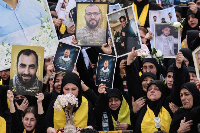 Mourners hold up portraits of Hezbollah fighters killed before a 10-day ceasefire was agreed between the Iran-backed militant group and Israel during a mass funeral procession in the southern village of Kfar Sir on April 21, 2026. Israeli defence minister said on April 21 that his country's campaign in Lebanon relied on both military and diplomatic pressure to disarm Iran-allied Hezbollah. Though a truce between Israel and Lebanon took effect on April 17, Israeli troops are still present and actively fighting Hezbollah militants in Lebanon's south. (Photo by Anwar AMRO / AFP)