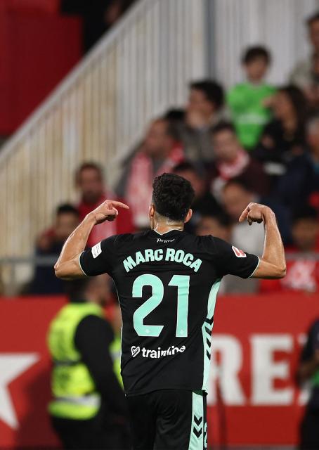 Real Betis' Spanish midfielder #21 Marc Roca celebrates scoring his team's first goal during the Spanish league football match between Girona FC and Real Betis at the Montilivi Stadium in Girona on April 21 , 2026. (Photo by Josep LAGO / AFP)