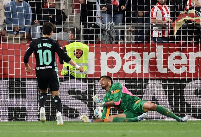 Real Betis' Moroccan forward #10 Abde Ezzalzouli scores his team's second goal in spite of Girona's Argentine goalkeeper #13 Paulo Gazzaniga during the Spanish league football match between Girona FC and Real Betis at the Montilivi Stadium in Girona on April 21 , 2026. (Photo by Josep LAGO / AFP)