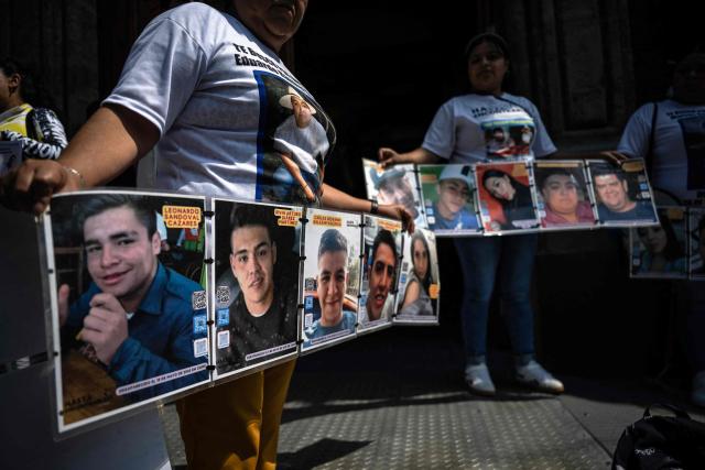 Relatives of disappeared people hold photographs of their loved ones during a protest outside the Cultural Center for Spain in Mexico City on April 21, 2026, while UN High Commissioner for Human Rights Volker Turk holds a meeting inside the building. (Photo by Carl de Souza / AFP)