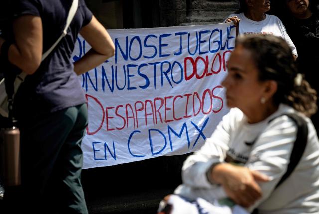 Relatives of disappeared people hold a banner reading "Do not play with our pain" during a protest outside the Cultural Center for Spain in Mexico City on April 21, 2026, while UN High Commissioner for Human Rights Volker Turk holds a meeting inside the building. (Photo by Carl de Souza / AFP)