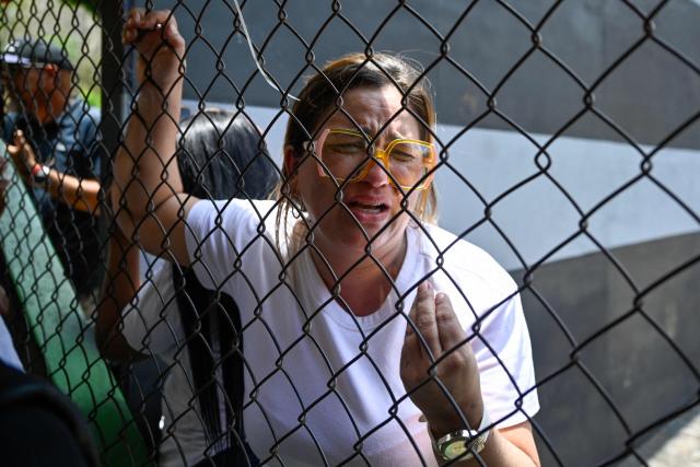 A relative of an inmate waits for news of her loved one outside the Yare prison in San Francisco de Yare, Miranda state, Venezuela, on April 21, 2026. At least five inmates died in a riot at a maximum-security prison in Venezuela, officials said on April 21. The deaths occurred the previous day at the Yare III prison, about 70 kilometers (40 miles) outside the capital Caracas, when fighting among prisoners "escalated into a riot", the Ministry of Penitentiary Services said in a statement. (Photo by Maryorin Mendez / AFP)