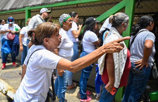 Relatives of inmates wait for news of their loved ones outside the Yare prison in San Francisco de Yare, Miranda state, Venezuela, on April 21, 2026. At least five inmates died in a riot at a maximum-security prison in Venezuela, officials said on April 21. The deaths occurred the previous day at the Yare III prison, about 70 kilometers (40 miles) outside the capital Caracas, when fighting among prisoners "escalated into a riot", the Ministry of Penitentiary Services said in a statement. (Photo by Maryorin Mendez / AFP)