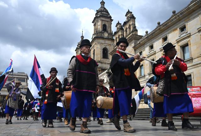 Misak Indigenous people play instruments during a protest to demand compliance with agreements reached with the government regarding their territories outside the Ministry of Foreign Affairs in Bogota on April 21, 2026. (Photo by Raul ARBOLEDA / AFP)