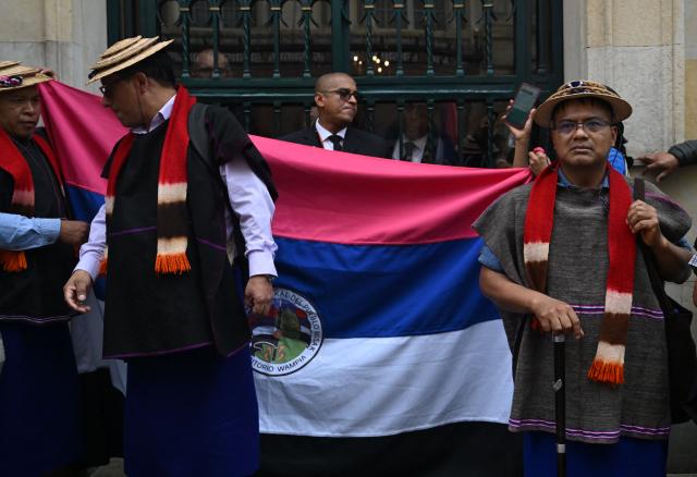 Misak Indigenous people block the entrance to the Ministry of Foreign Affairs during a protest to demand compliance with agreements reached with the government regarding their territories in Bogota on April 21, 2026. (Photo by Raul ARBOLEDA / AFP)