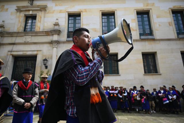 A Misak Indigenous man speaks through a loudspeaker during a protest to demand compliance with agreements reached with the government regarding their territories outside the Ministry of Foreign Affairs in Bogota on April 21, 2026. (Photo by Raul ARBOLEDA / AFP)